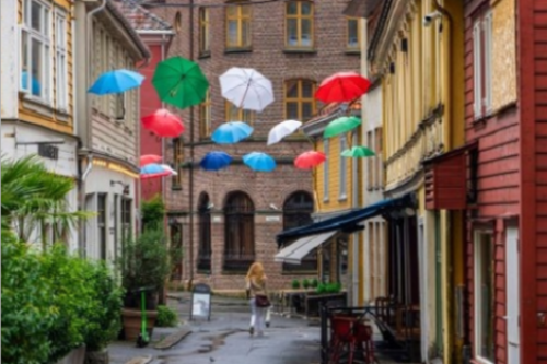 Skostredet gate i Bergen med fargerike trehus og gatekunst.
