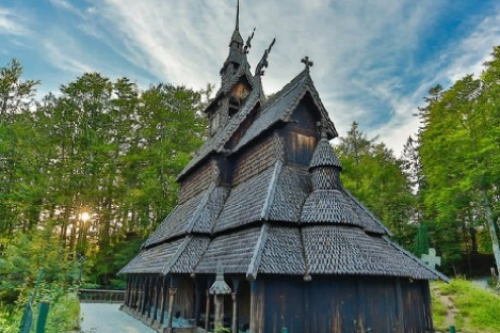 Fantoft Stavkirke, en historisk replika kirke, omgitt av skog.